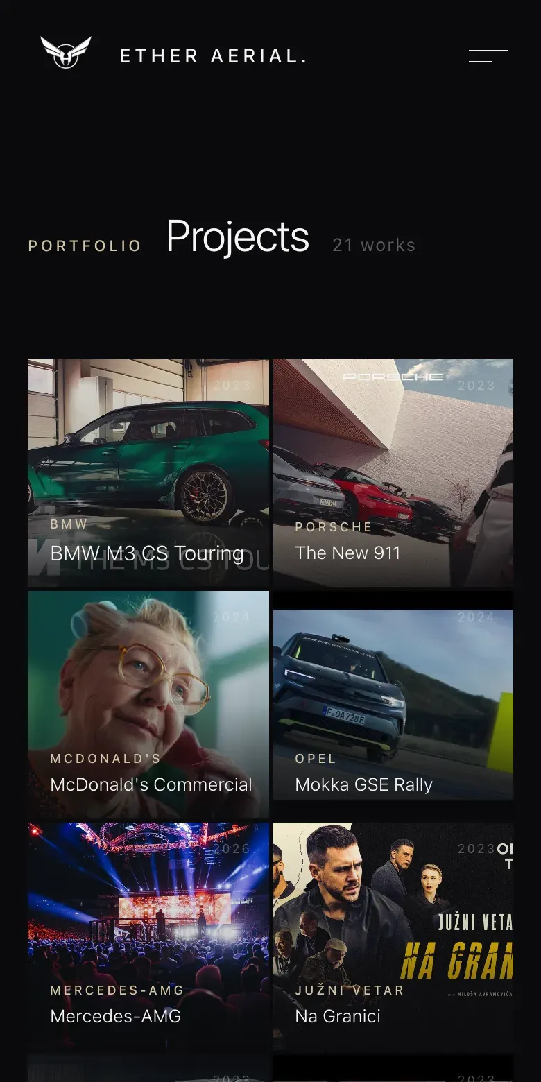 The projects index on a phone: the same dark page with a two-column mosaic of project stills and titles.